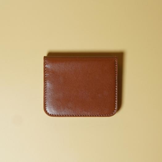 Tan Brown leather wallet on a beige background