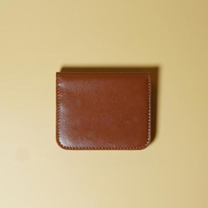 Tan Brown leather wallet on a beige background