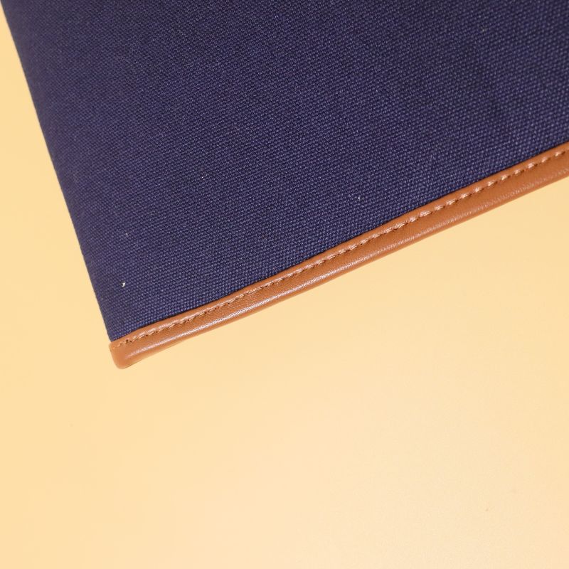 Document holder and laptop sleeve in Canvas with leather trims-Deep Blue Canvas with tan leather trim-gold plated metal snap button-beige felt lining-detail zoomed view-The Bicyclist 