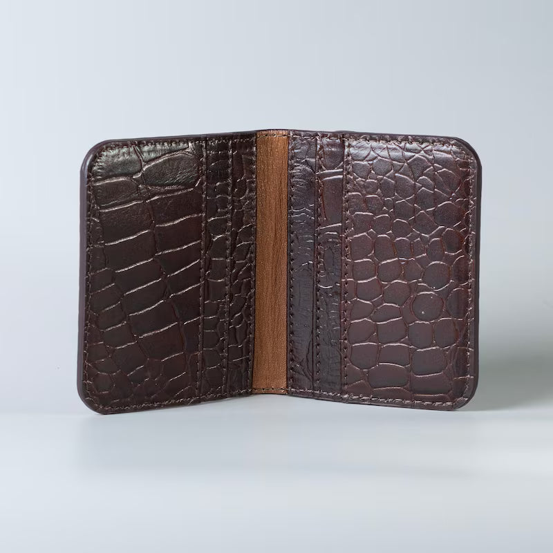 Open view of a Full grain leather maroon slim bifold card wallet in corocodile leather texture with six card slot from The Bicyclist on a soft grey background 
