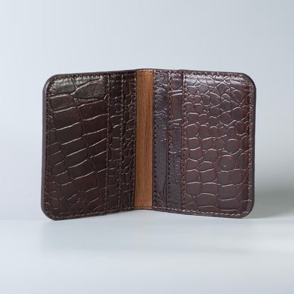 Open view of a Full grain leather maroon slim bifold card wallet in corocodile leather texture with six card slot from The Bicyclist on a soft grey background 