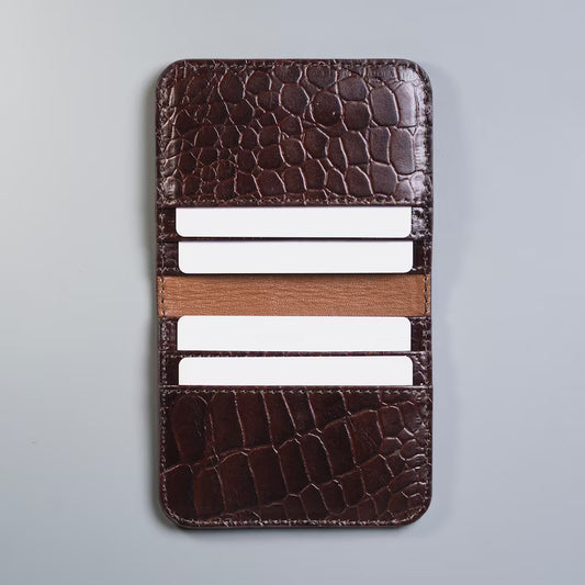 Open View of Full grain leather maroon slim bifold card wallet in corocodile leather texture with six card slot from The Bicyclist with white plastic cards inserted on a soft grey background 