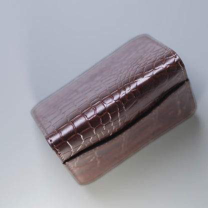 Top deatil view of a bifold card wallet in full gain leather with crocodile leather texture on a light grey background