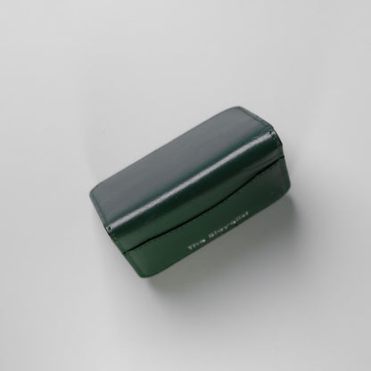Image taken from the top of a full grain leather bifold card wallet standing upright made by 'The Bicyclist', on a soft grey background