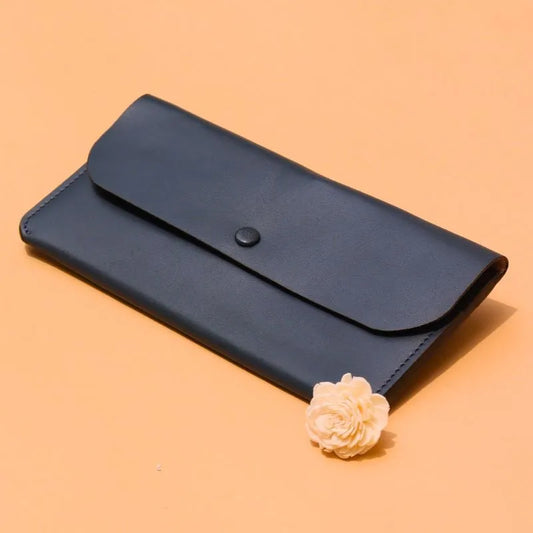 Handmade Leather Long Wallet for Women in Deep Blue on a peach background with a white dry flower