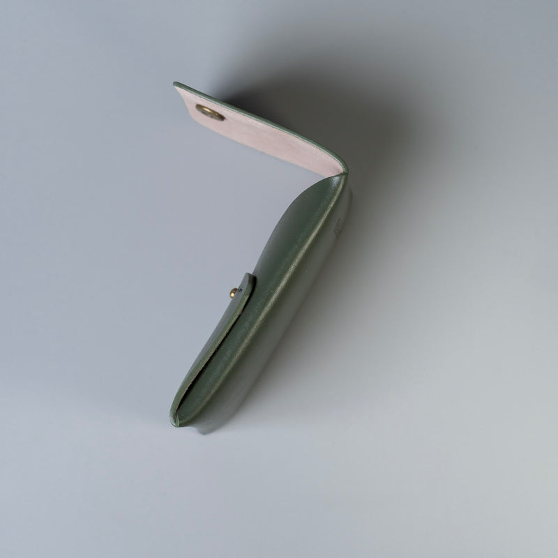 A small olive green full grain leather card holder or card wallet with a flap shown open at an angle, revealing a light beige felt interior lining and gold-tone metal snap hardware, set against a clean light gray background.