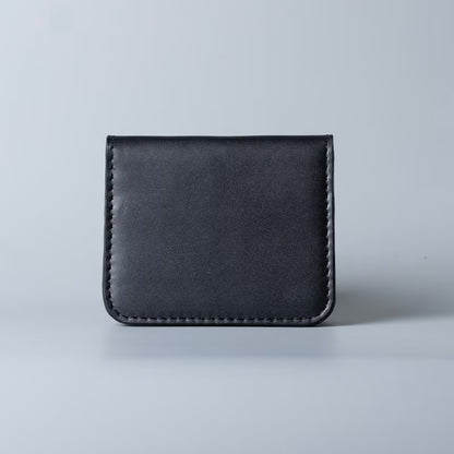 A minimalist black leather card holder or wallet with visible stitching along the edges, photographed against a clean light gray background.