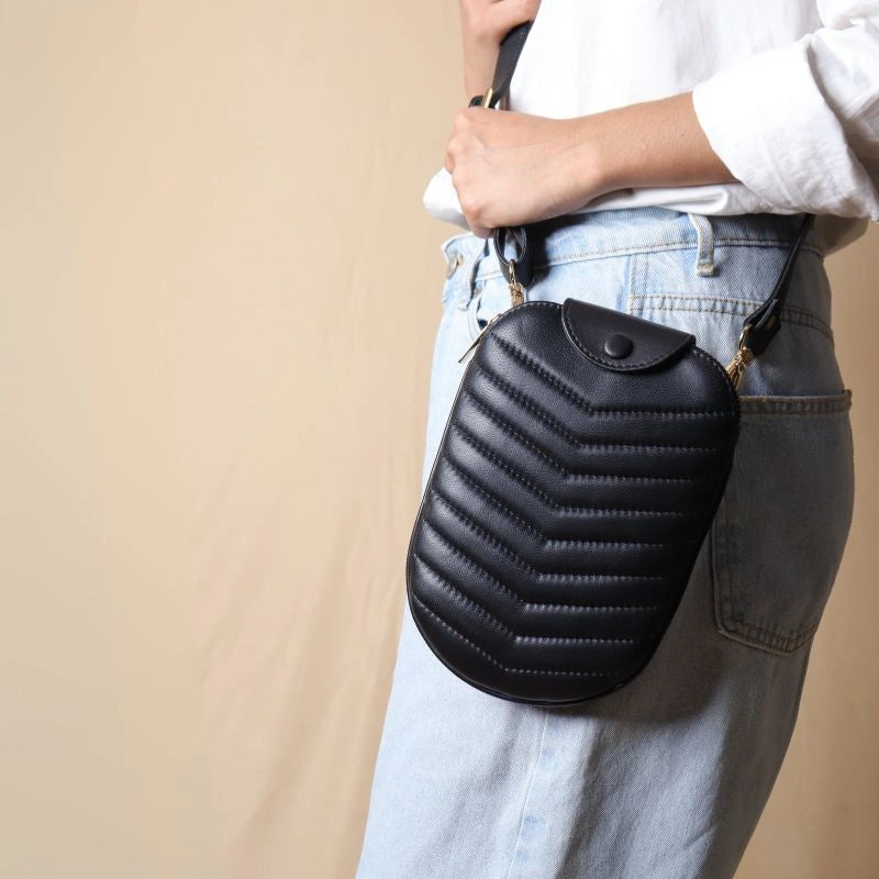 Woman Carrying a little black quilted leather sling pouch 