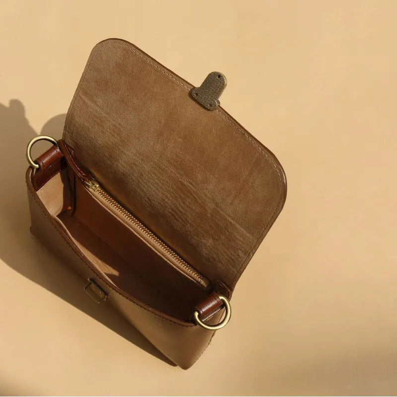 Top Internal View of a Dark Brown Leather Crossbody Sling Bag with Flap and a Light Gold Pushlock and beige felt lining and a gold zip