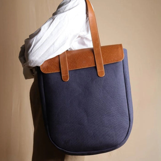 Woman in white shirt carrying a Deep Blue Tote bag with Tan Leather Flap and Tan Leather Straps