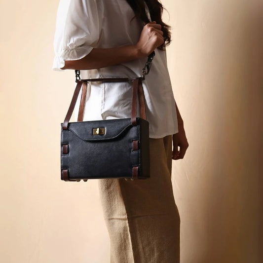 Structured Box Black Leather Shoulder Handbag with Dark Brown straps carried by a woman in white shirt 