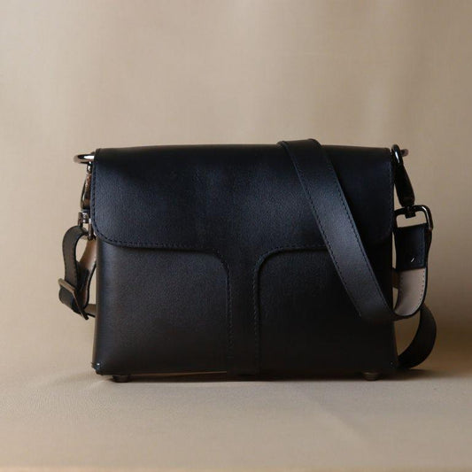 Front View Black Handmade leather sling bag with Polished black gunmetal fittings on a beige background