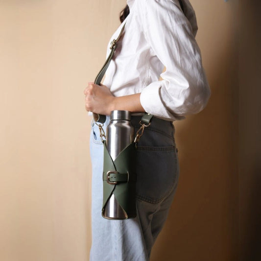 Woman carrying an adjustable leather bottle carrier with a stainless steel bottle
