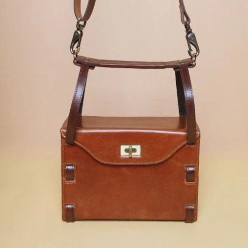 Front View of Tan Leather structured box crossbody handbag with dark brown straps and golden twist lock