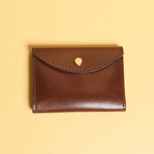 Dark Brown Bifold Leather Wallet with a Flap  Closure with a metal Snap Button in Gold Metal Finish and Three Card pockets with two cards in each pocket and one cash pocket  with a tan sheep leather lining front view