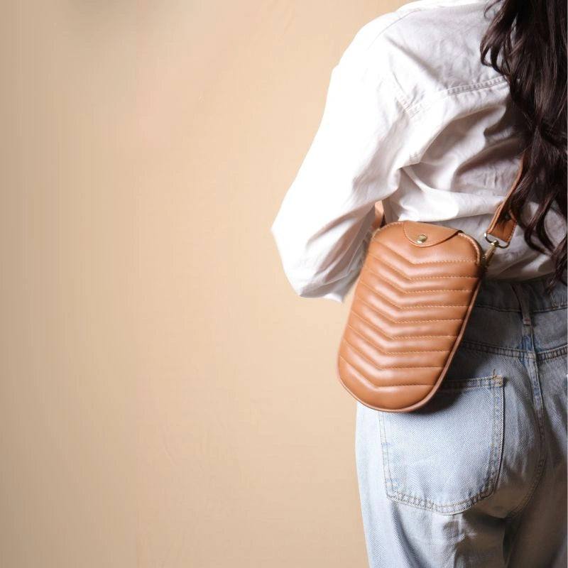 Back View of a Woman in a white shirt wearing a leather quilted crossbody sling pouch across her body 