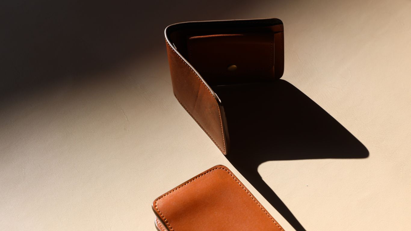 a pair of Full Grain Handmade Leather bifold coin wallet from 'The Bicyclist' top wallet standing up and bottom wallet laying flat  