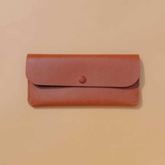 Front view of a leather long wallet for women in tan with flap