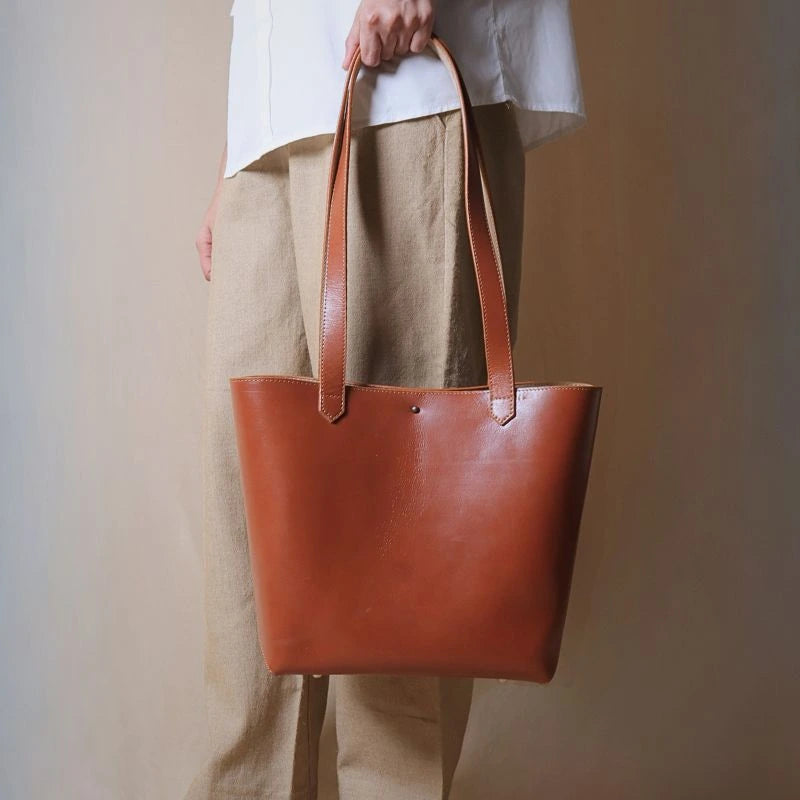 Woman holding a tan leather tote bag