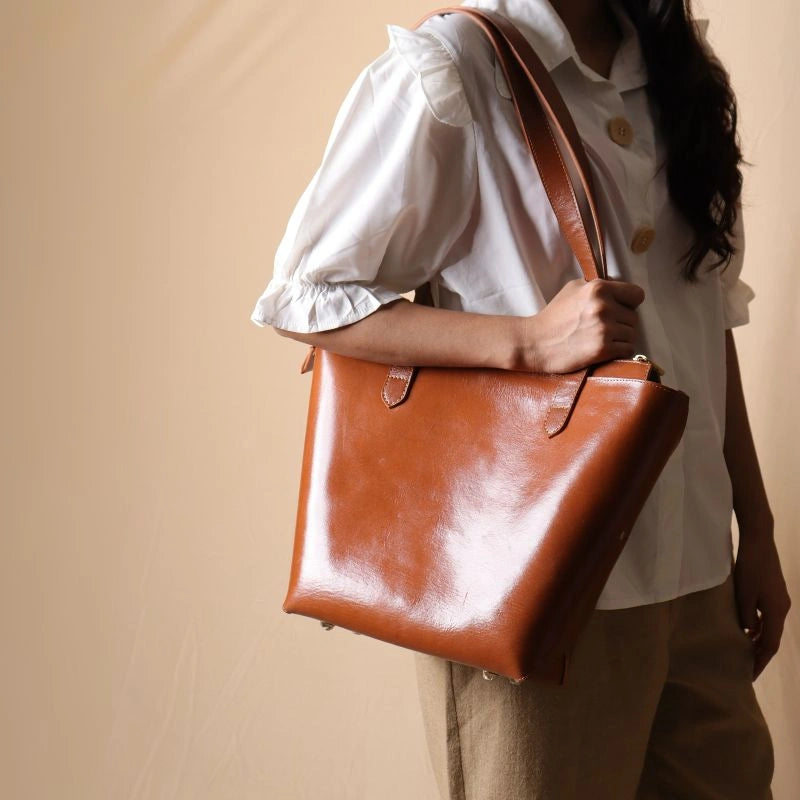 Zipped Leather Shoulder Tote Bag in Tan carried by a woman over her shoulder wearing a white shirt