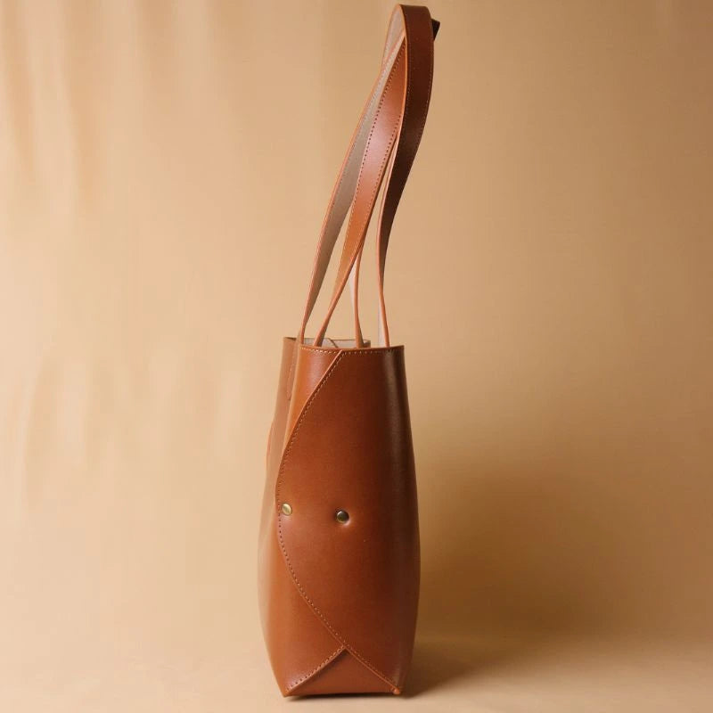 Side view showing the rivets of a structures leather tote handbag