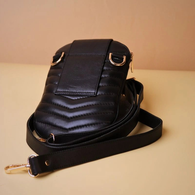 Back view of a little black quilted leather phone pouch bag showing a belt hoop along with golden fittings and a long strap